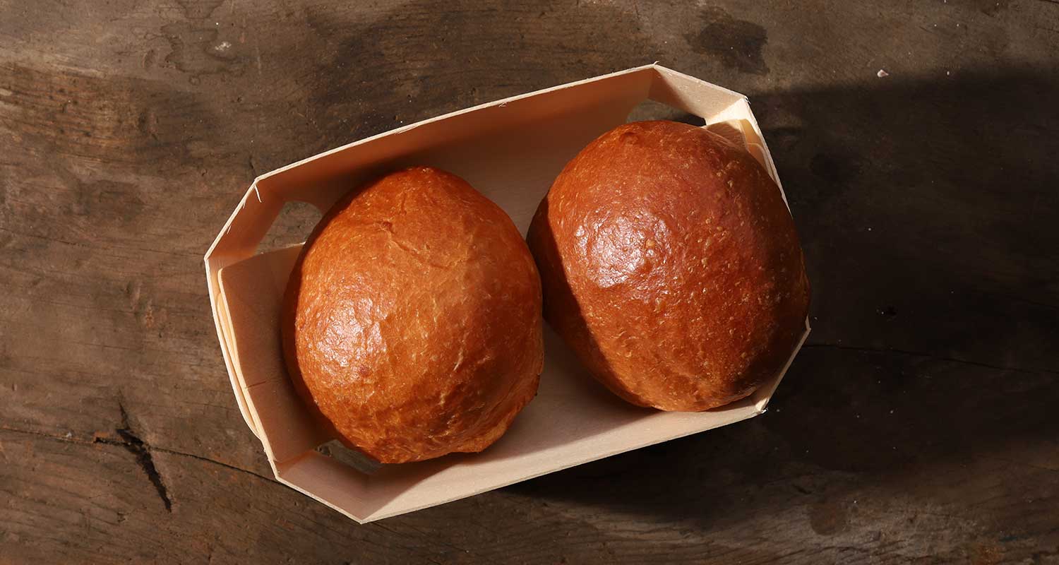 Top view of two brioche rolls in Standard Baking Company basket