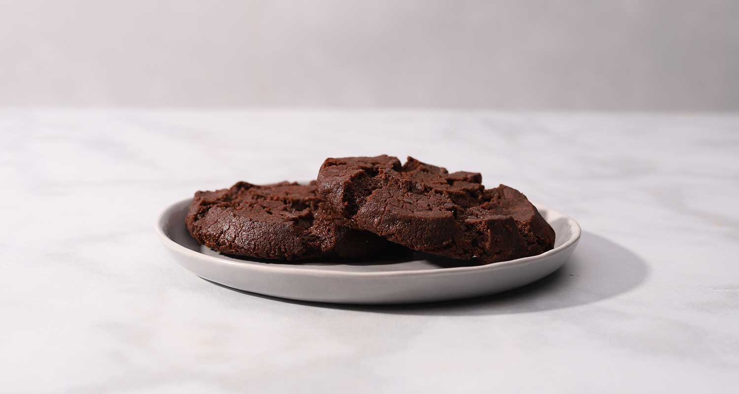 side view of two chocolate sable cookies